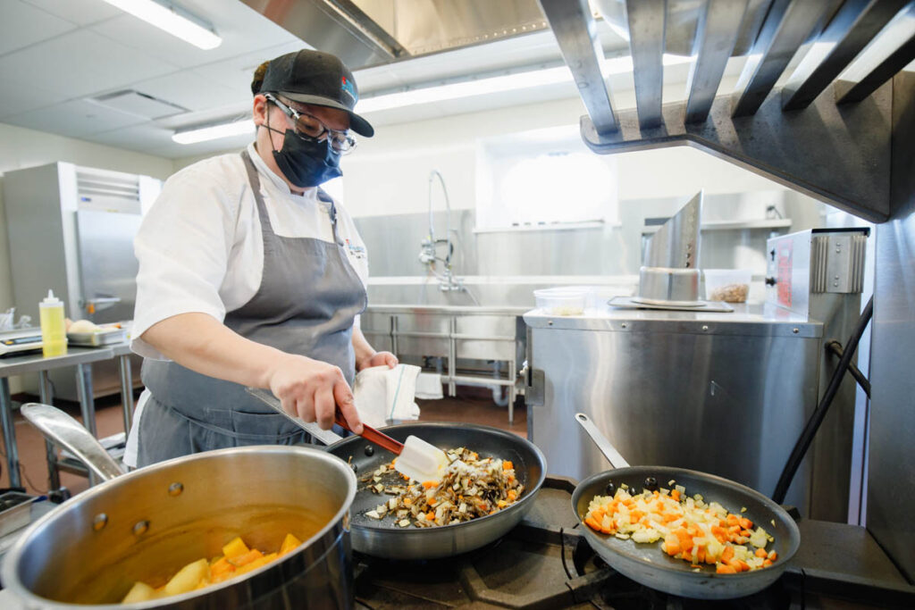 Culinary student frying up food in a kitchen