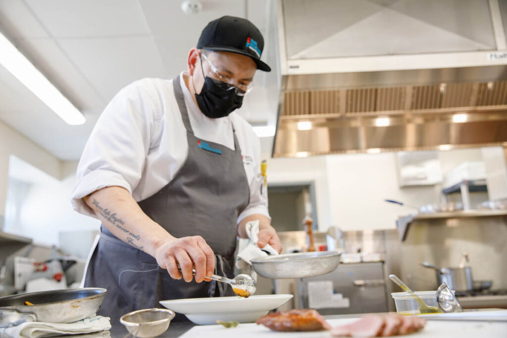 Culinary student in a kitchen preparing a dish