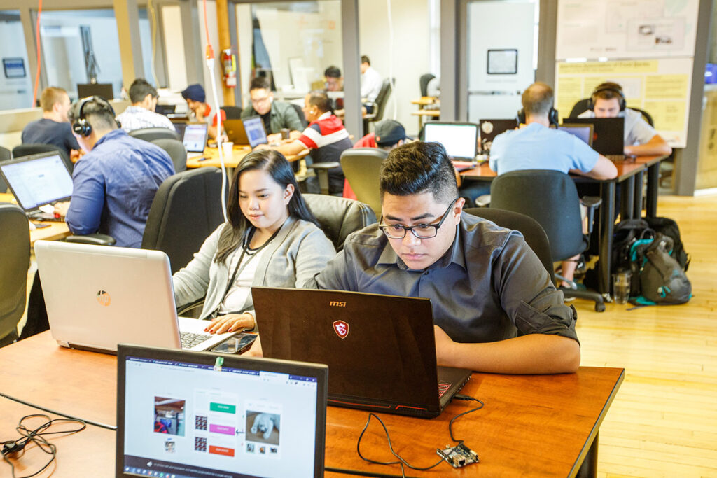 Students in a classroom looking at their laptops