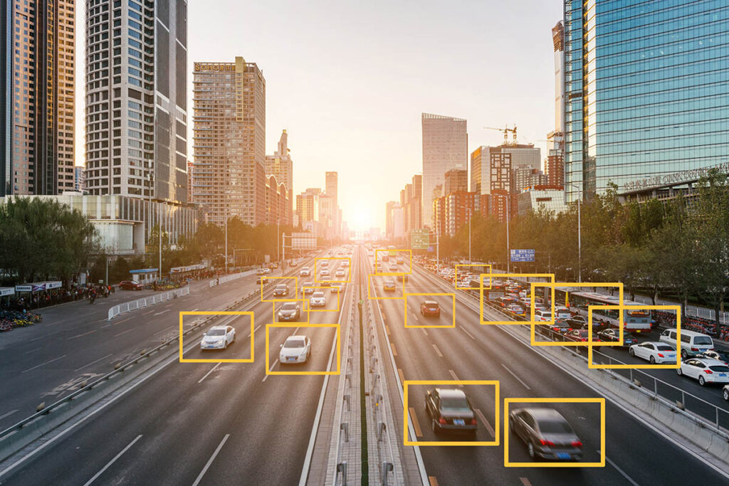 Photo of a highway cutting through a city with AI drawing yellow squares around cars on the road