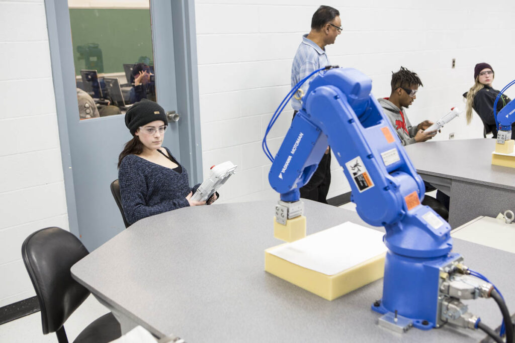 Student in a robotics lab learning how to maneuver a robot
