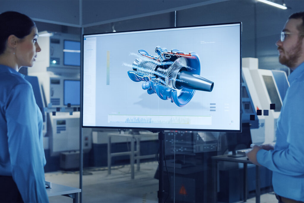 Two people in a lab looking at a screen with a cross-section of a turbine displayed on it