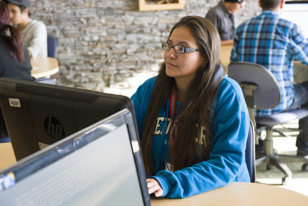 Woman sitting in front of a computer in a computer lab