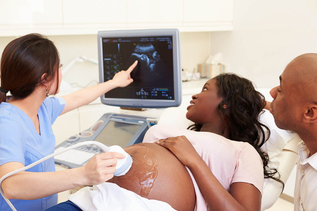 Medical professional taking ultrasound of pregnant woman