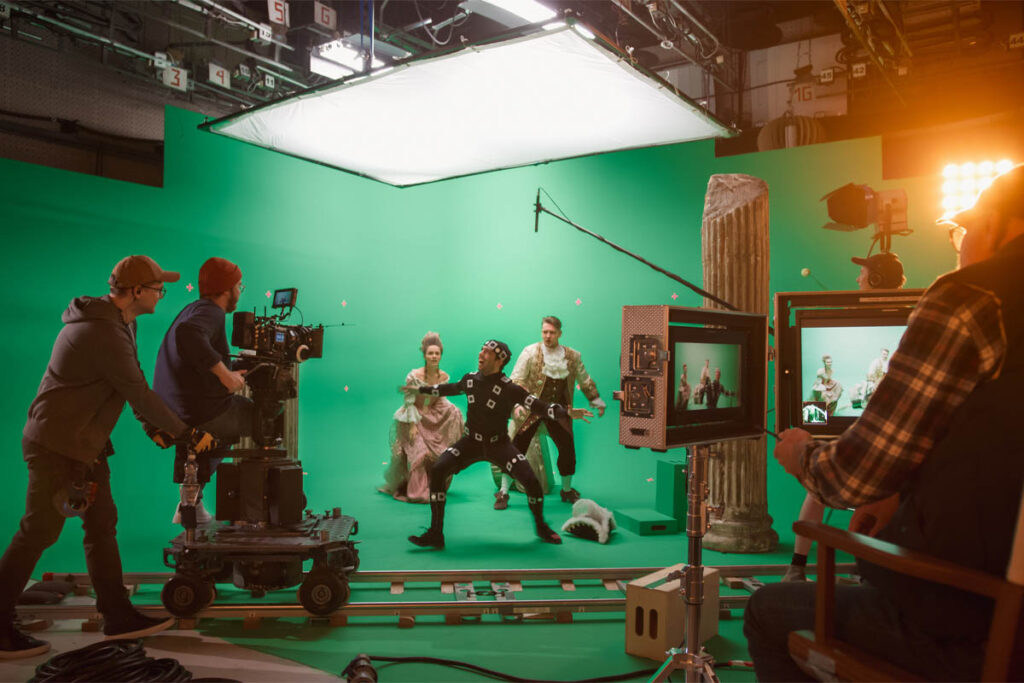 Actors in front of a green screen while the camera crew films them