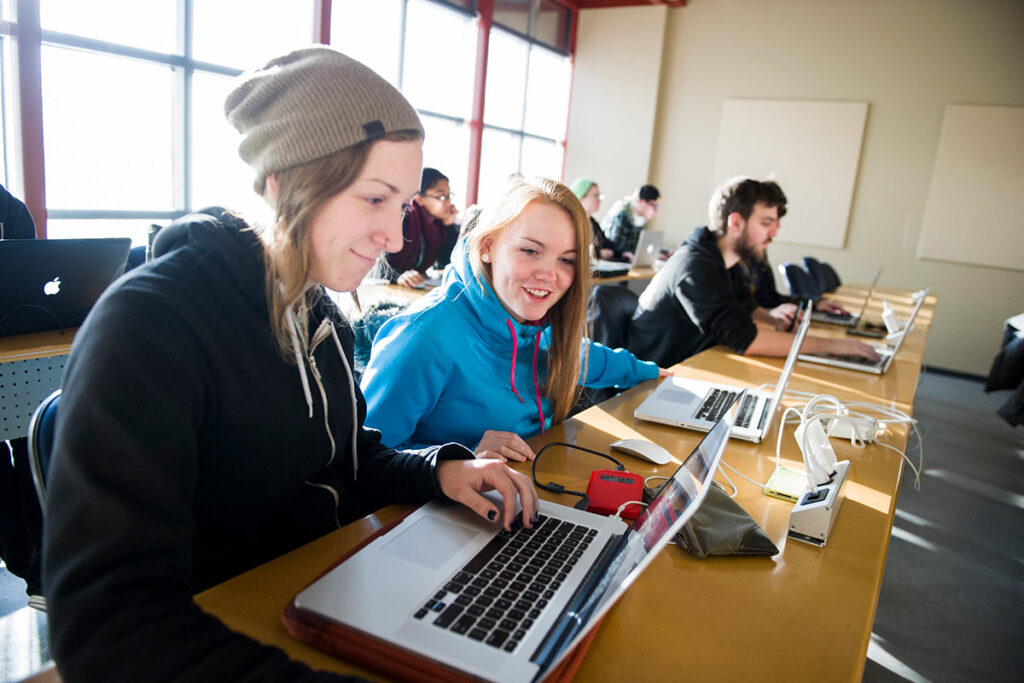 Students looking at laptops in a classroom