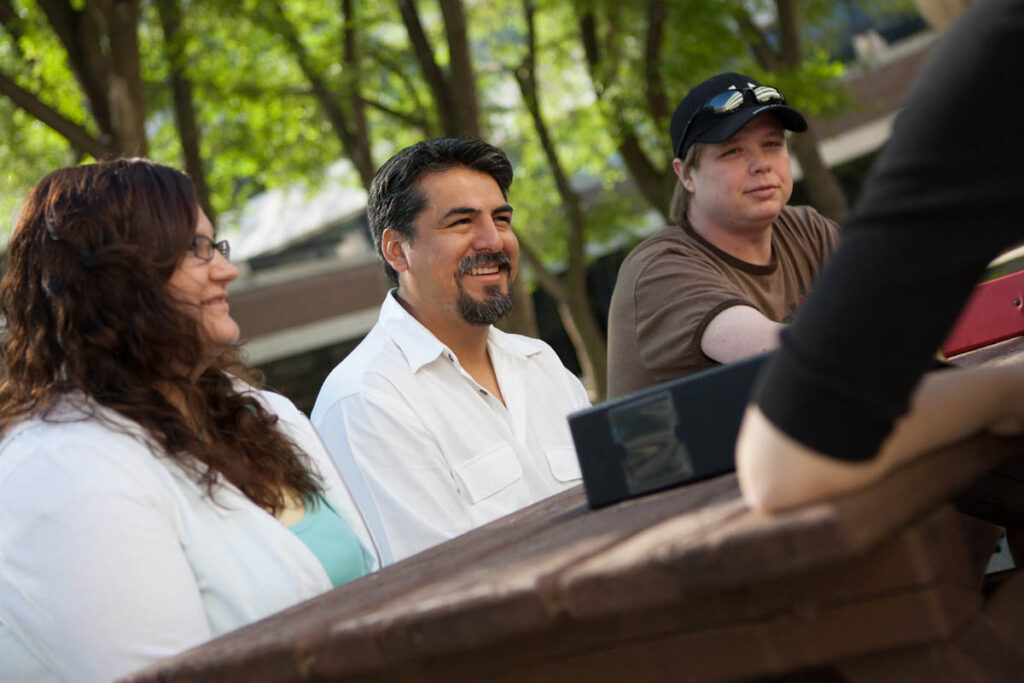 Group of people sitting outdoors at a picnic table