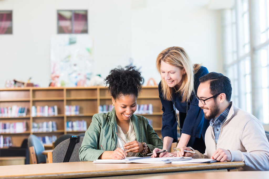 Instructor talking to students in a library