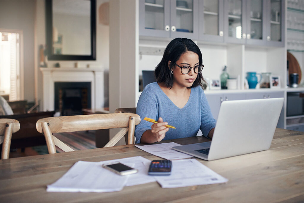 Woman working on laptop in her dining room