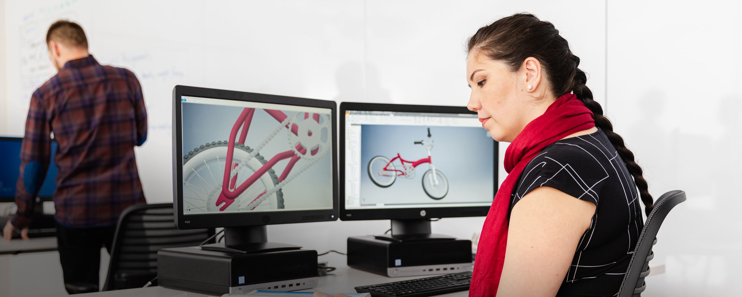 Woman working with CAD files on two monitors
