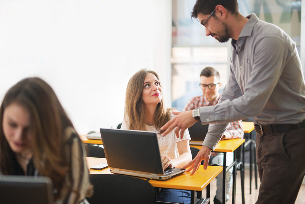 Instructor talking to student in a classroom