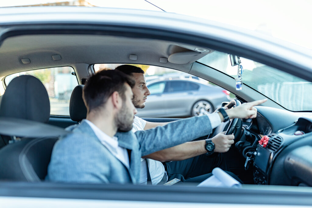 Driving instructor and student sitting inside a car