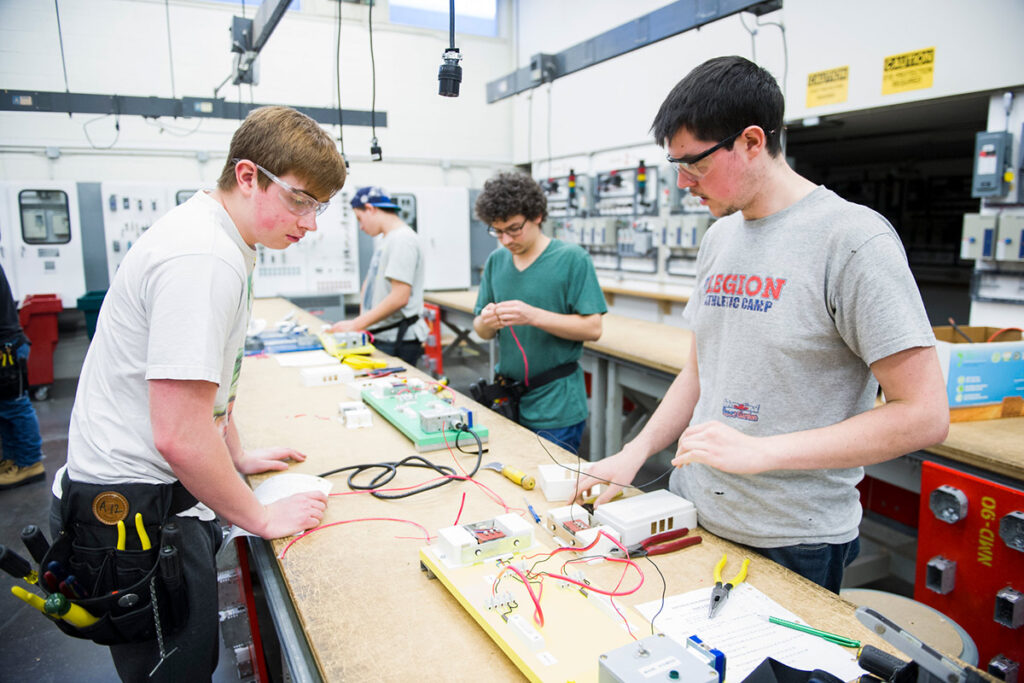 Electrical students learning how to check voltage in a training lab