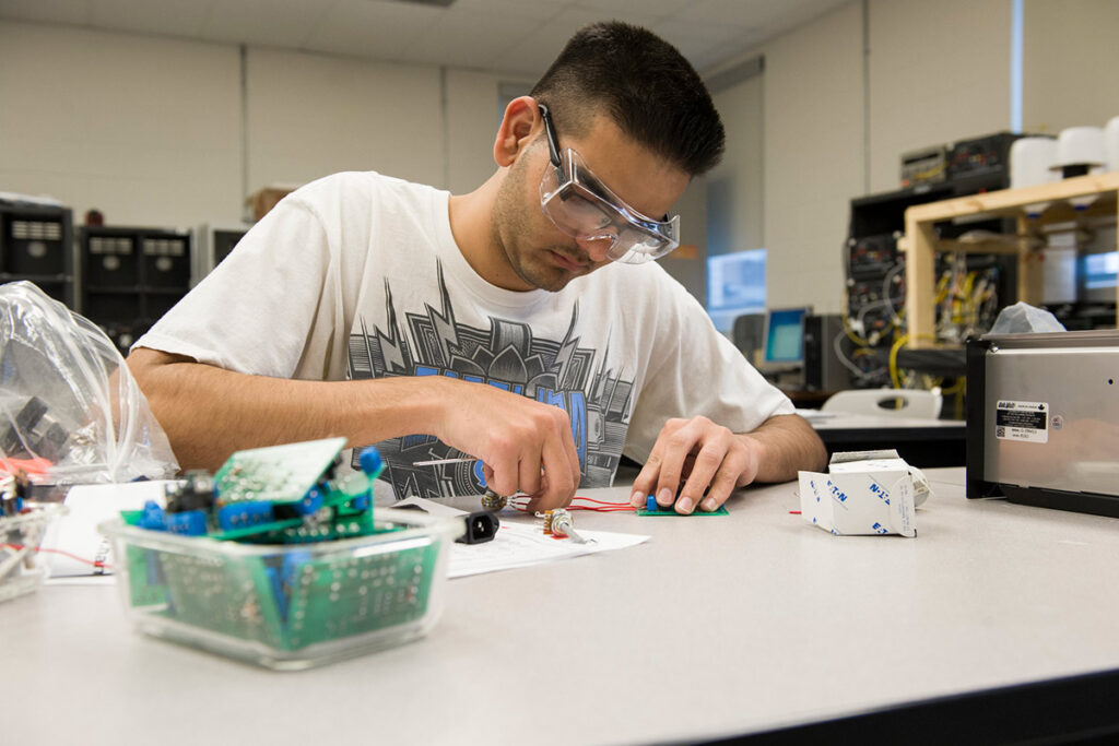 Student in a lab splicing cables