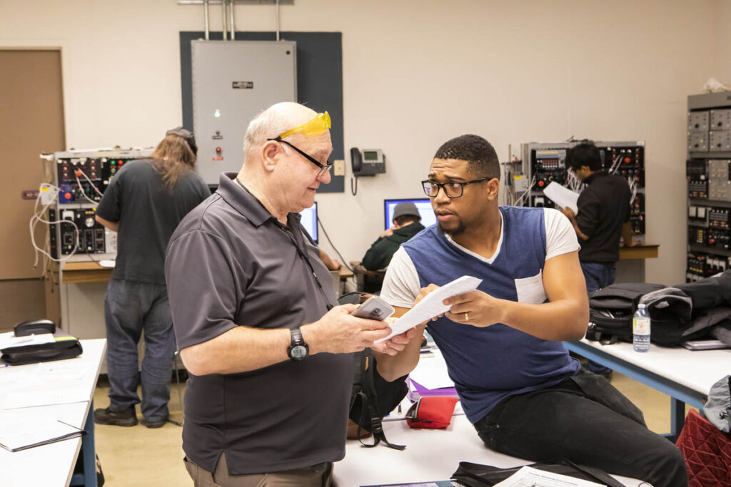 Instructor talking to student in an electrical engineering lab