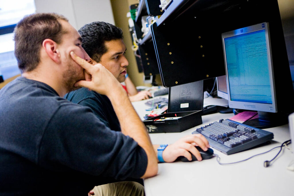 Two students working on a computer in an electronic engineering lab