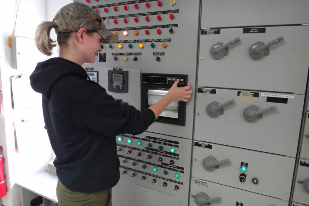 Student working the control board for a water treatment plant