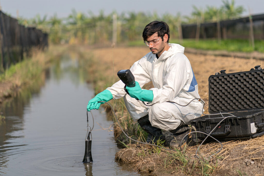 Man taking water samples from irrigation ditch