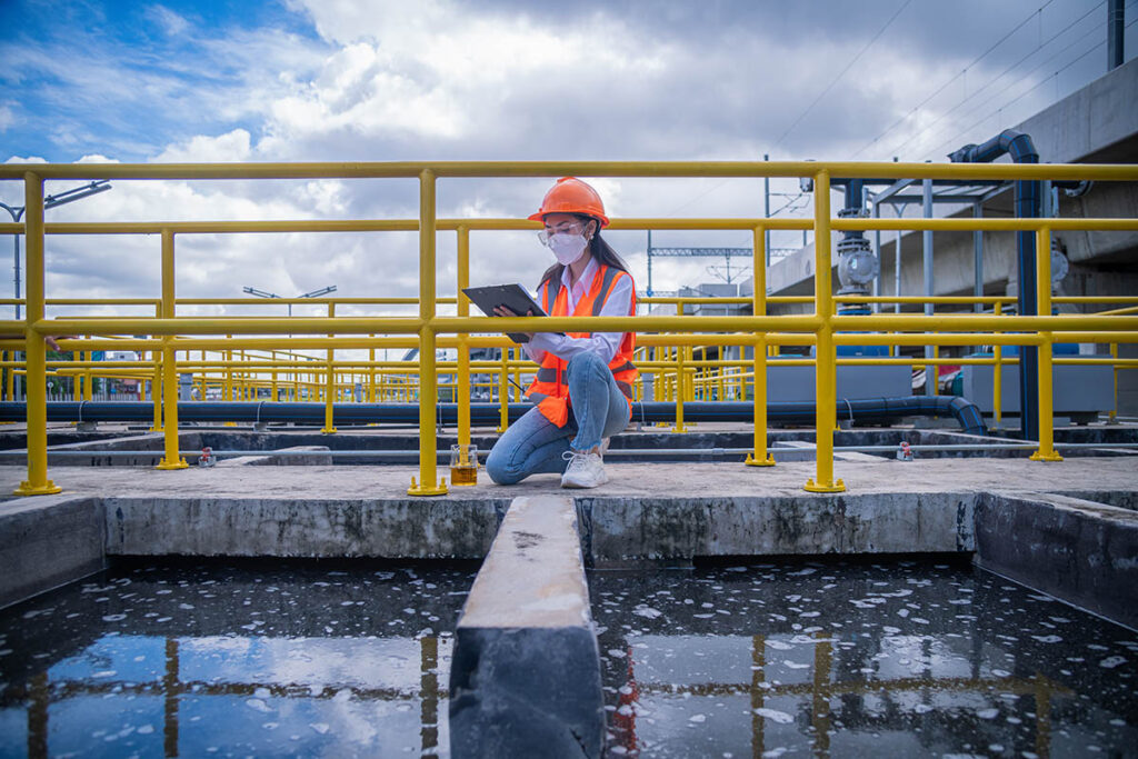 Person taking notes on tablet at water treatment plant