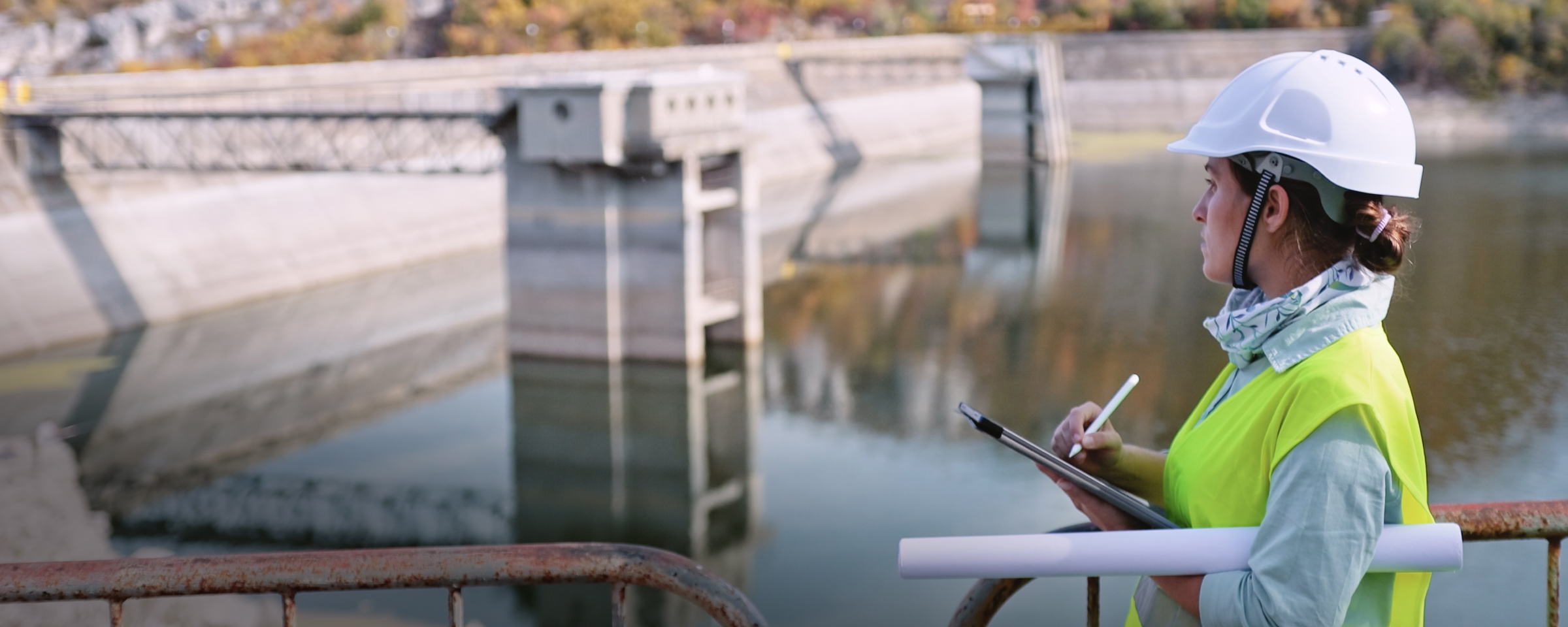 Engineer making notes while inspecting a dam