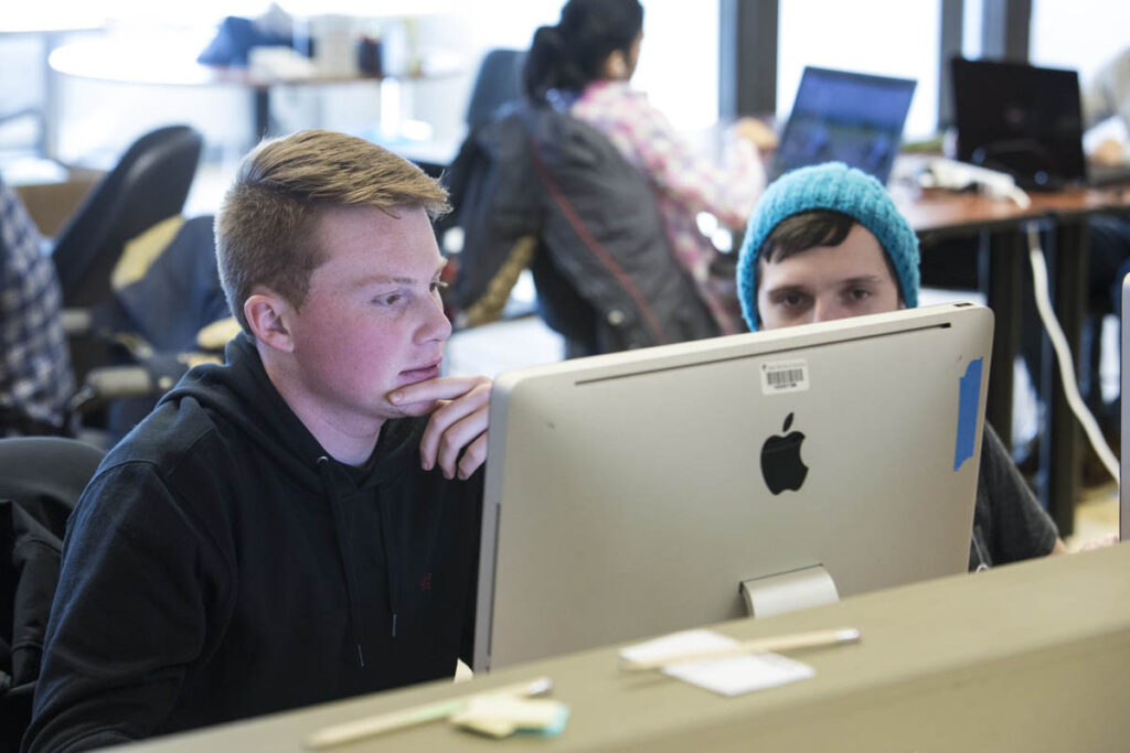 Students in classroom looking at a computer screen 