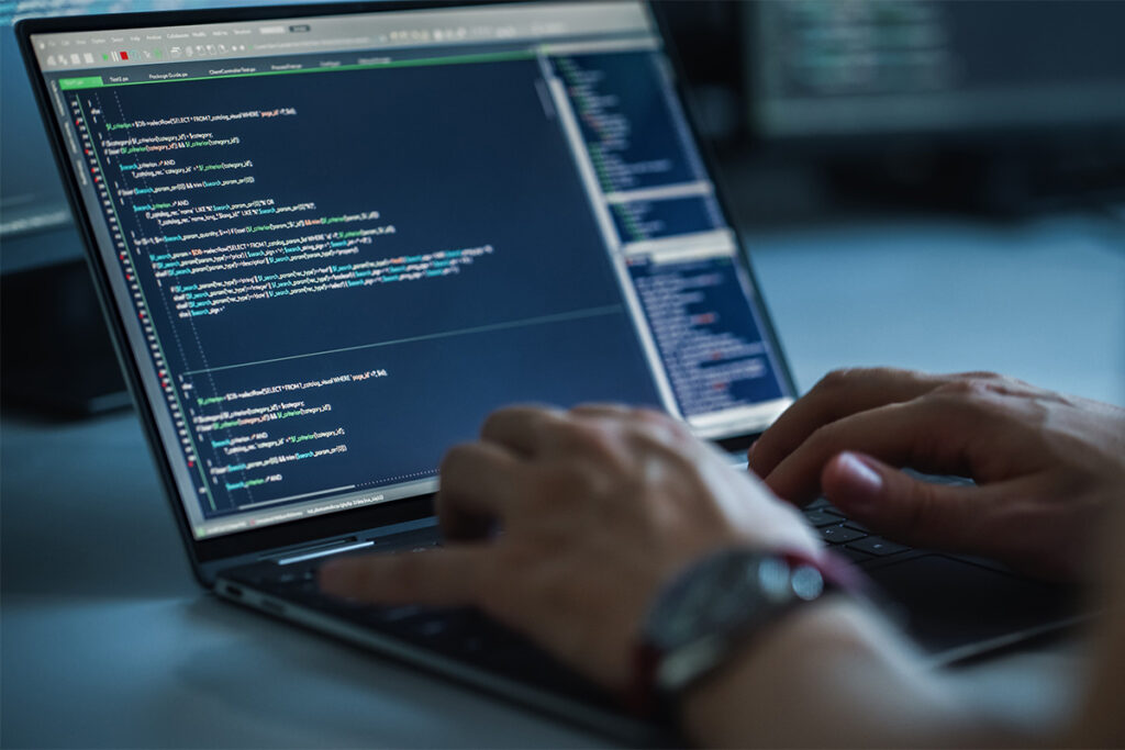 Close up of person coding on a laptop