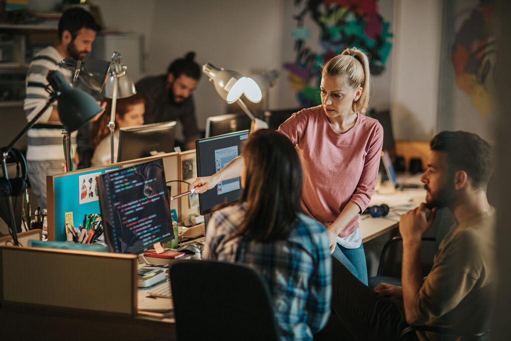 Group of people reviewing code on a computer monitor