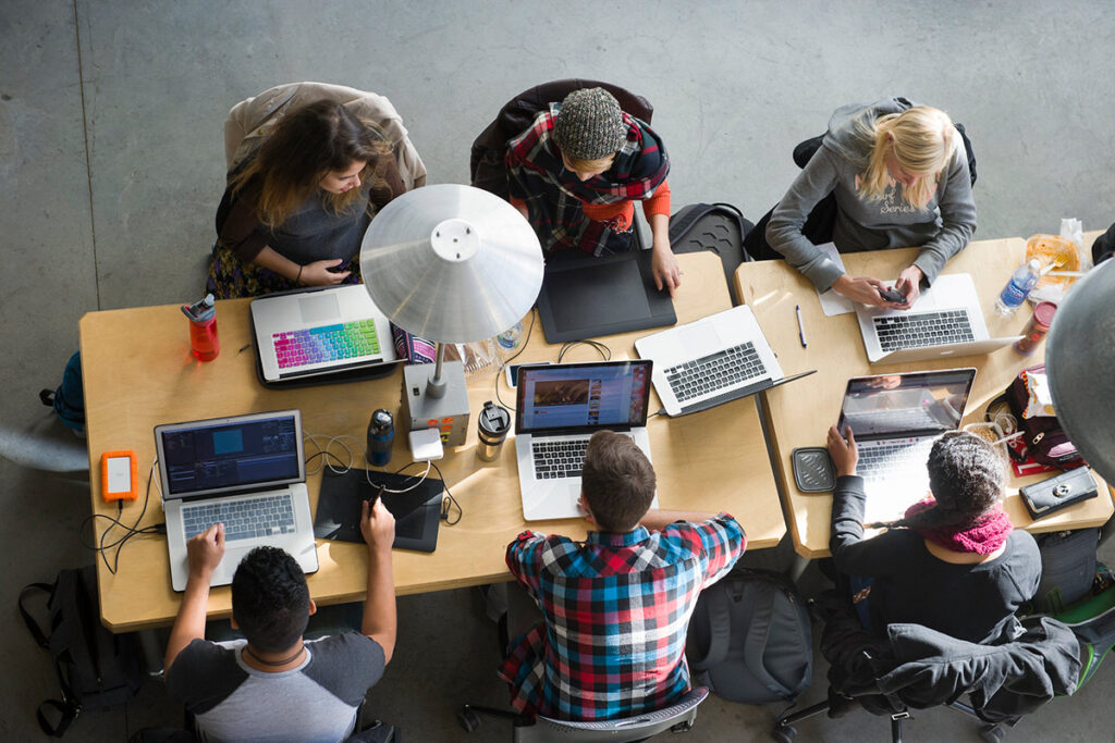 Birds Eye view of students working on laptops in an open workspace on campus