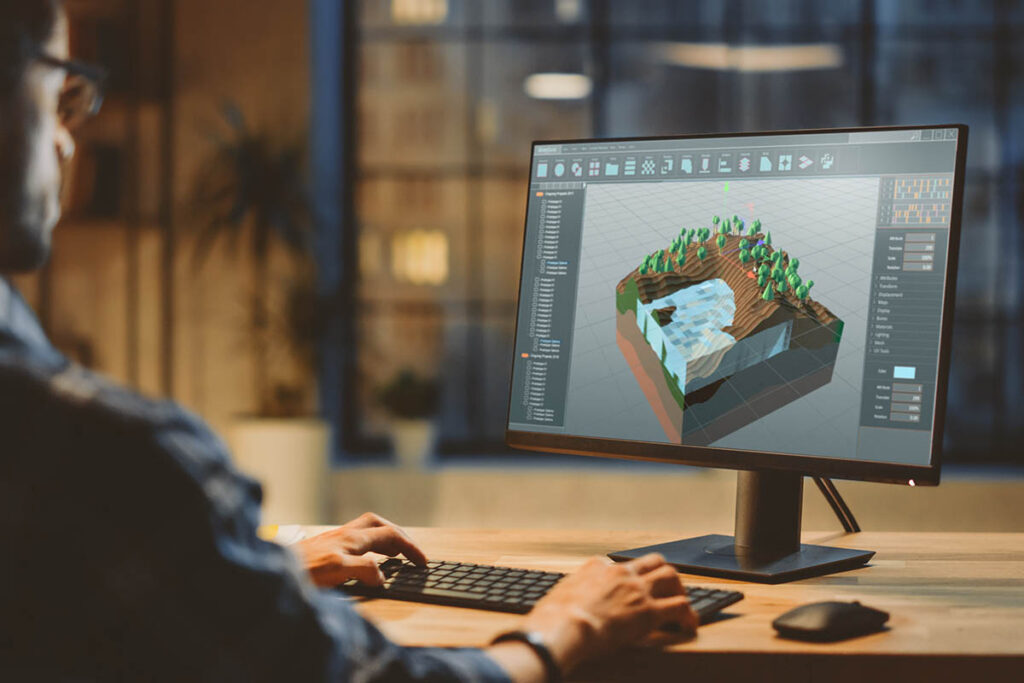 Man sitting at a computer and creating a 3D model of some terrain and water