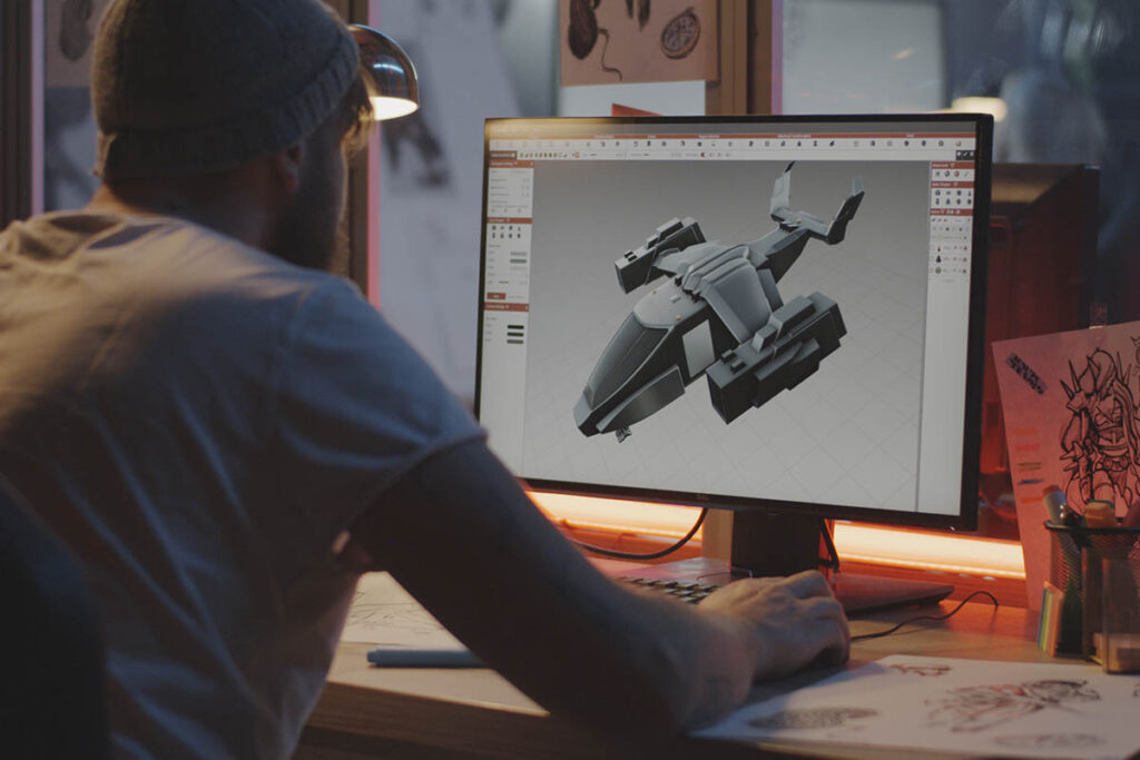Person creating a 3D model of a flying spaceship on a computer