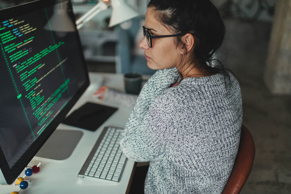 Woman coding on a desktop computer