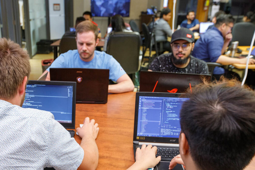 Group of students working on laptops in a classroom