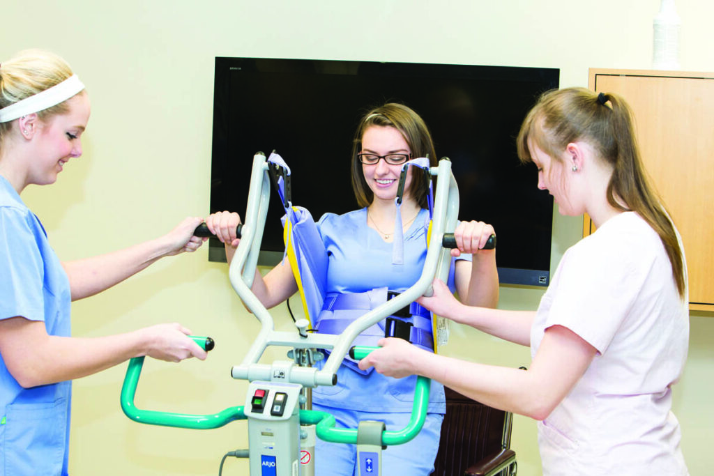 Health care aides learning to use medical equipment