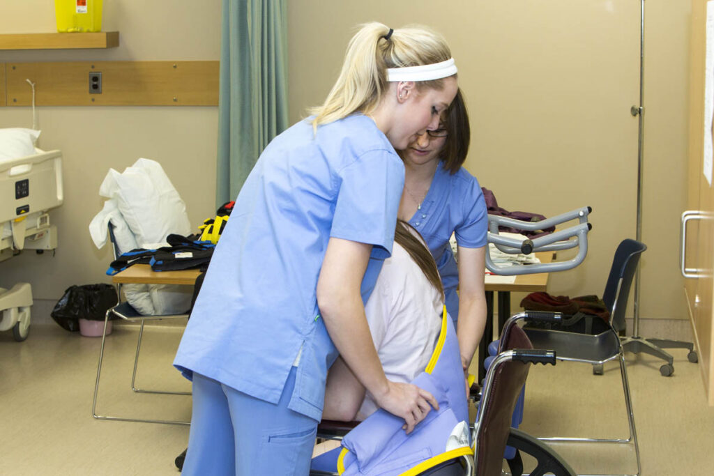 Nurses assisting patient into wheelchair