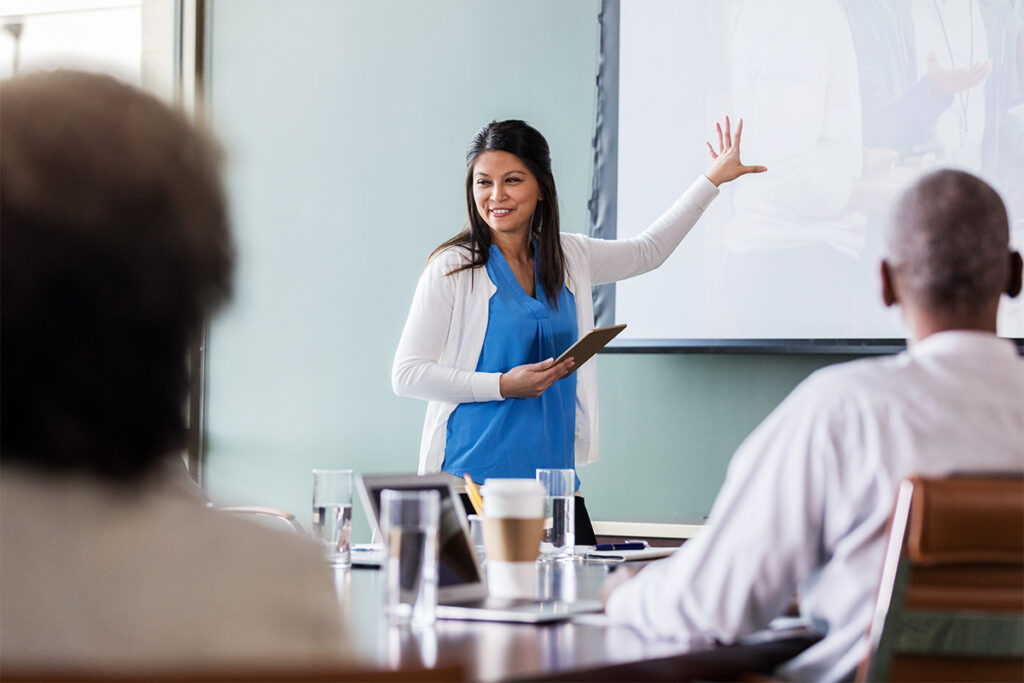 Woman making a presentation to a group of colleagues in a meeting room
