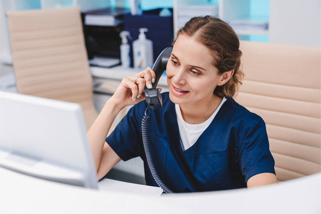 Health unit clerk talking on the phone in a hospital