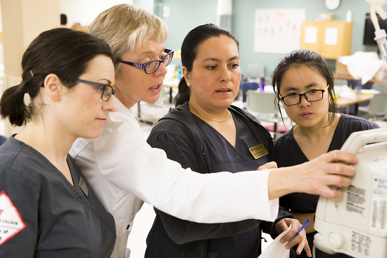 Nursing instructor showing nursing students how to operate a device