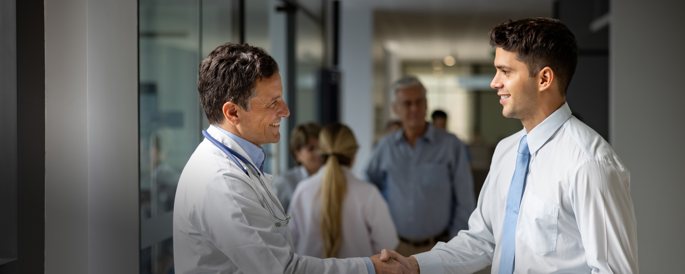 Two men shaking hands in a healthcare setting