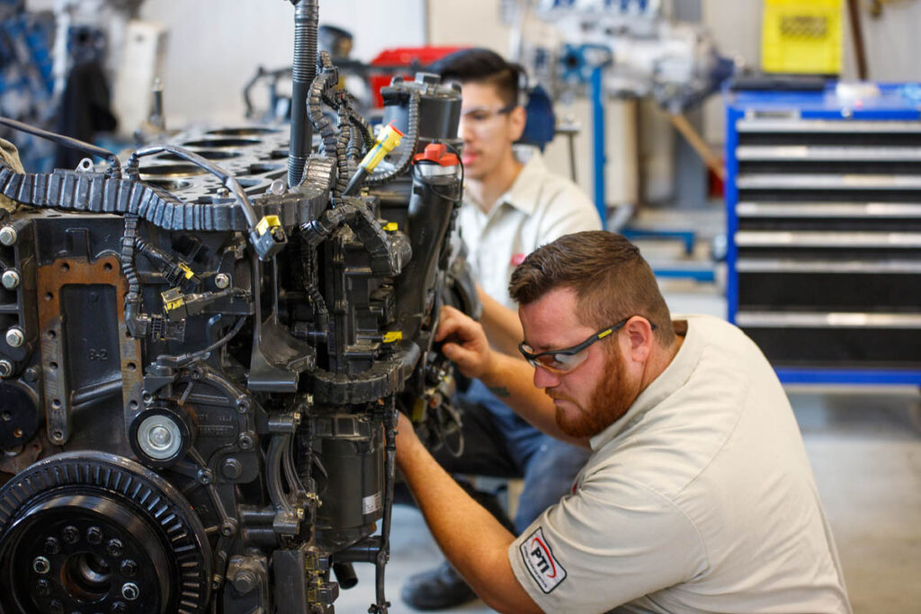 Mechanic student working on a large vehicle's engine