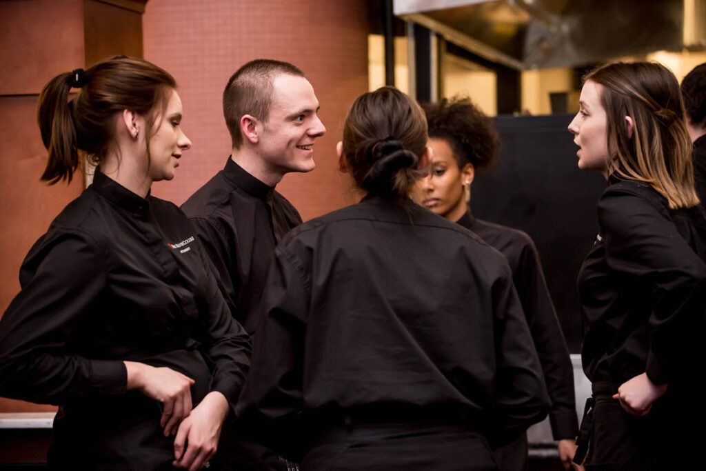 Hospitality students talking to one another in a restaurant