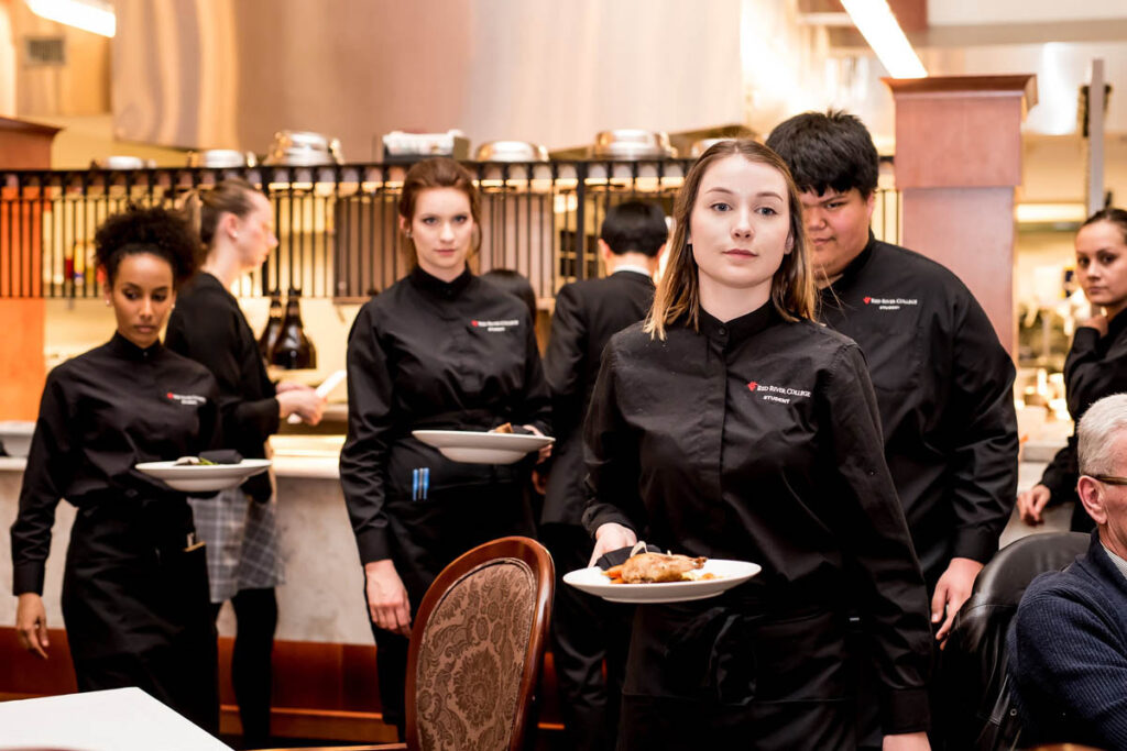 Servers carrying food in a restaurant