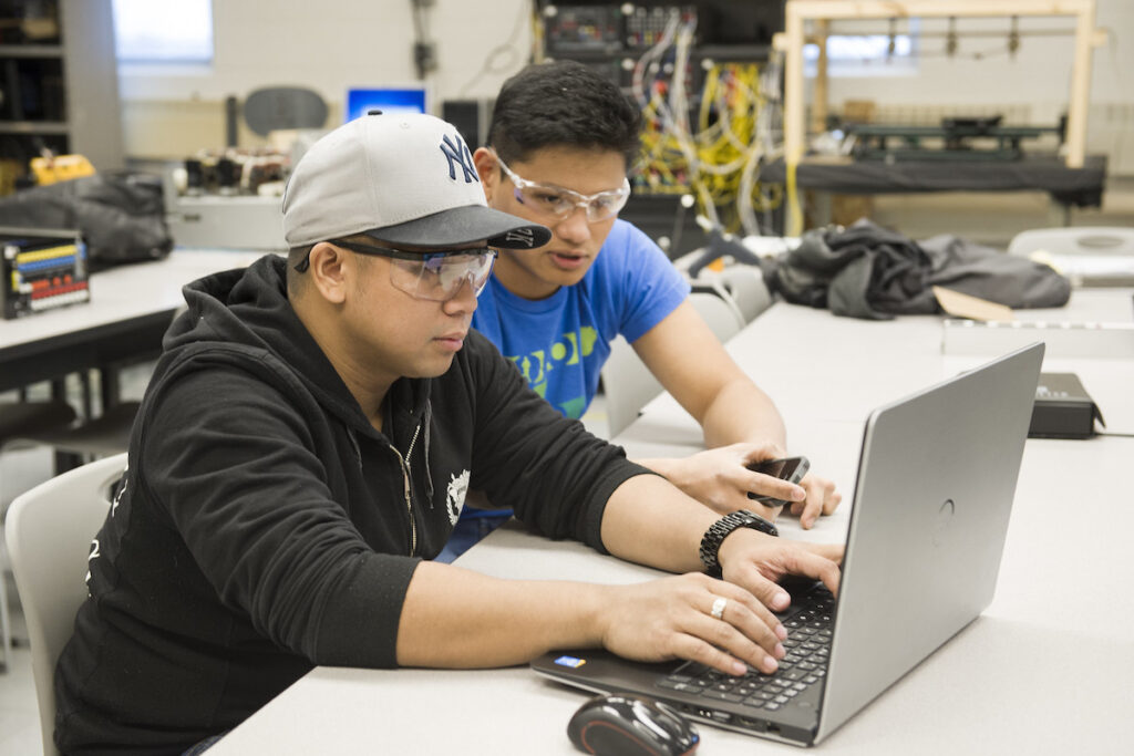 Students working on a laptop in an electrical student lab