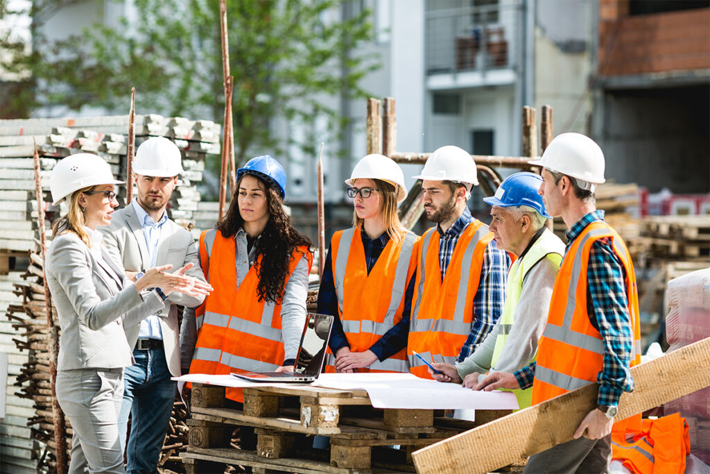 Group of people listening to somebody give instructions at a construction site