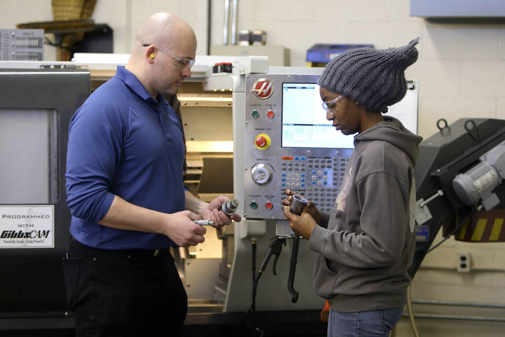 Instructor talking to student in a CNC lab
