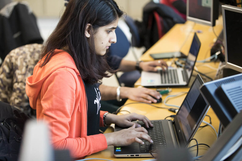 Girl working on laptop in a classroom