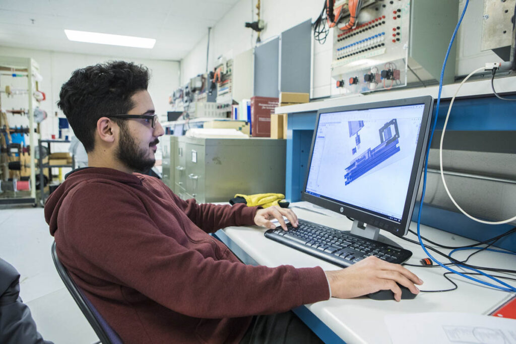 Student in a computer lab looking at a 3D rendering of an instrumentation control