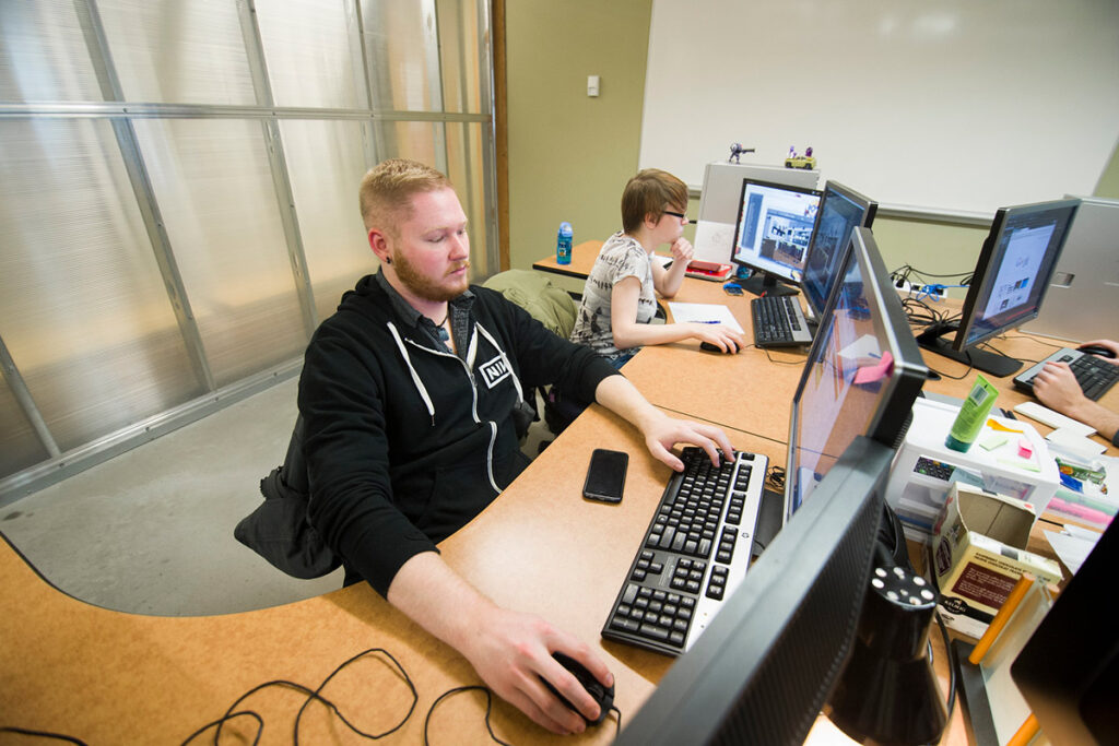 Students sitting in a lab and working on computers