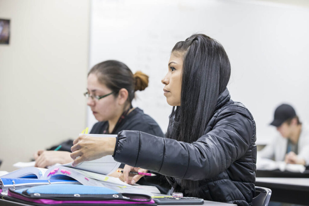 Students reading a textbook in a classroom