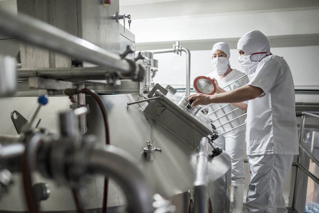 People wearing protective gear in a food manufacturing plant
