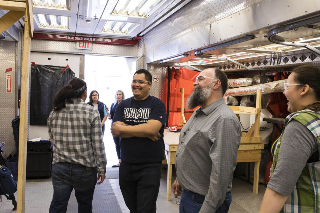 Instructor and student talking and looking at HVAC system